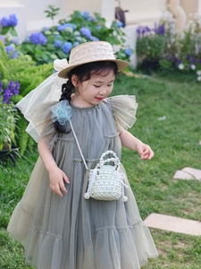 Détail de la robe en tulle pour fille avec chapeau de paille perlé et mini sac perlé