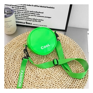 Detail of round green kids shoulder bag with COOL text and wide fashion strap