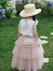 Detail of girls' summer outfit featuring white lace top and pink tulle tiered cake skirt