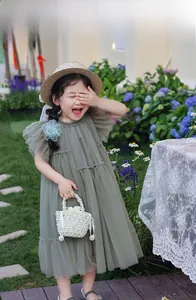 Détail du sac à main en perles blanches associé à une robe en tulle vert pour fille