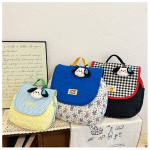 Three quilted kids bags with cute cartoon dog charms in floral and checkered patterns