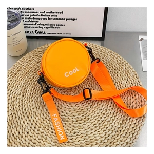 Detail of round orange mini crossbody bag with COOL lettering and nylon strap