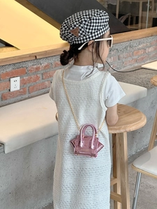 Detail of metallic pink mini crossbody bag with gold chain strap for children