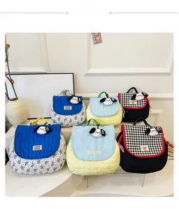 Detail of quilted canvas backpacks for kids with cute plush 3D puppy dog charms
