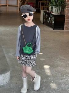 Fillette mannequin portant un mini sac bandoulière vert tendance et un béret gris