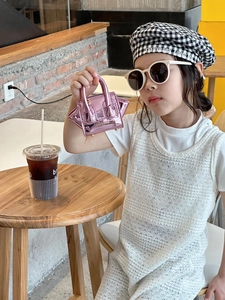 Close-up of pink laser patent leather mini crossbody bag for kids with gold chain detail