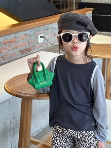 Gros plan du mini sac trapèze vert vif en cuir texturé litchi avec logo doré élégant