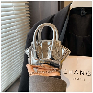 Detailed view of silver metallic mini bag featuring a chain strap and dual handles