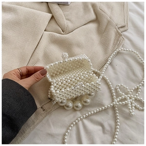 Detailed view of handmade pearl mini bag featuring woven beads and large pearl handle