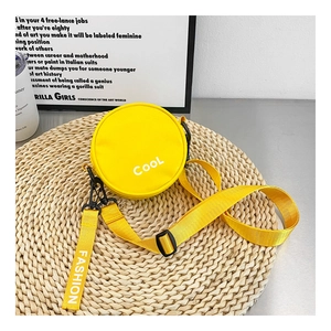 Close-up of yellow round canvas crossbody bag with Cool print on woven mat