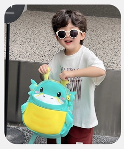 Detail view of cartoon dinosaur backpack for kids with 3D wings and horns in bright blue