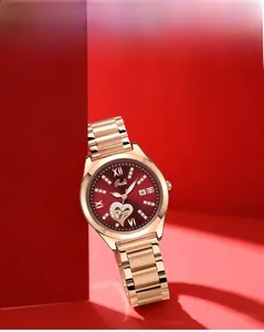 Detail of rose gold ladies quartz watch with red dial, date window and diamond accents