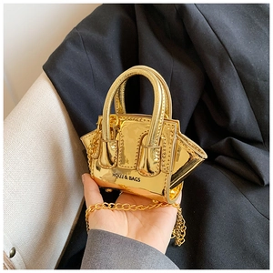 Detail of a mini gold metallic leather crossbody bag with chain and logo lettering