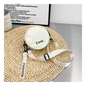 Detail of white round boy's crossbody bag with CooL letter print and wide fabric strap