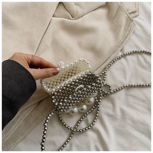 Close-up of handmade faux pearl and silver metal bead woven crossbody bag for kids