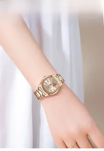 Detail of luxury rose gold steel watch with rhinestone bezel on female wrist