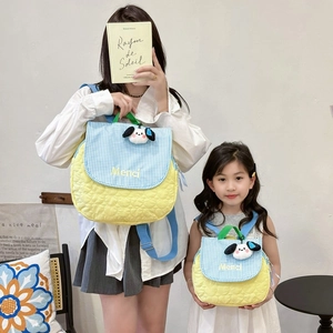 Matching yellow quilted backpacks for kids and adults with cute dog pendant and Merci text