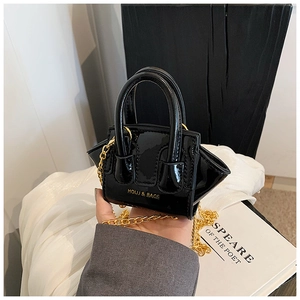 Close-up of black patent leather mini crossbody bag with gold chain and logo detail
