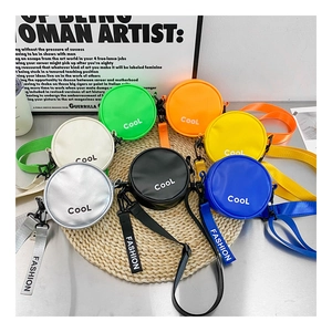 Flat lay of colorful round mini crossbody bags with Cool and Fashion lettering on straw mat