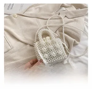 Close-up of pearl woven mini bucket bag with satin drawstring liner and chain strap