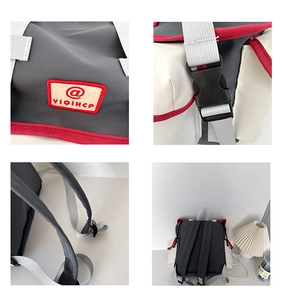 Detail of multi-color casual backpack featuring gray fabric, red trim and plastic buckle