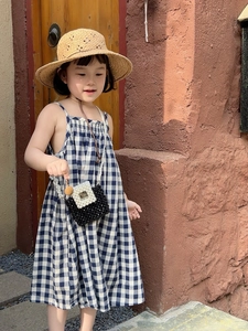 Outdoor shot of a girl wearing a stylish plaid dress and a pearl chain handbag