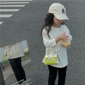 Détail d'un mini sac à bandoulière en cuir vert et blanc pour enfants stylés