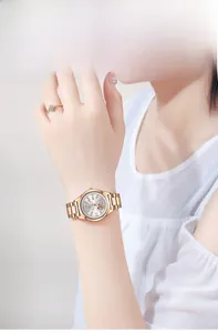 Detail of rose gold watch with heart hollow dial and crystal index on female wrist