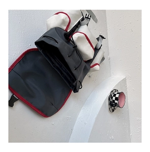 Detail of multi-pocket functional backpack with red piping and durable buckle closures