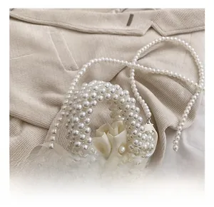 Close-up of handmade pearl woven handbag with beaded handle and satin lining detail