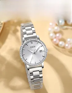Detail of luxury women's watch with rhinestone bezel, date window, and pearl accents