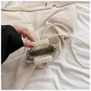 Detailed view of handmade pearl woven mini bag with silver bead accents and long chain