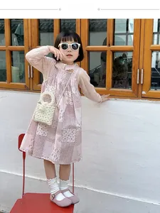 Outdoor model showcase of pink floral girl's dress with pearl handbag and accessories