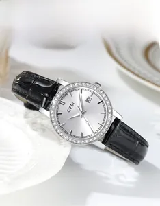 Detail of silver sunray dial watch with crystal bezel and calendar window on leather strap