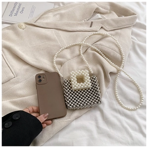 Mini silver beaded handbag size comparison with a smartphone showing its compact square design