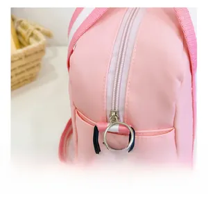 Details einer rosa Nylon-Umhängetasche mit Reißverschluss und gestreiftem Gurt