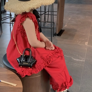 Kids vibrant red sleeveless dress with ruffle sleeves and stylish black mini crossbody bag