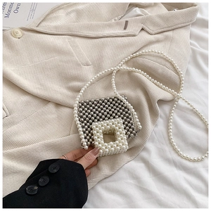 Detail of silver beaded mini crossbody bag with white pearl chain strap and flap
