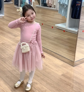 Detail view of pink princess dress styled with pearl crossbody bag and Mary Jane shoes