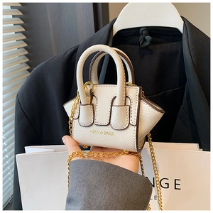 Détail du nano sac blanc en cuir grainé avec sa bandoulière en chaîne dorée chic