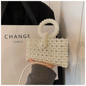 Detailed view of handmade white pearl woven handbag with round handle and beaded chain