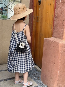 Outdoor shot of a girl in a blue plaid dress with a pearl chain mini crossbody bag
