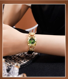 Detail shot of Gedi vintage square watch featuring dark green dial and gold metal band