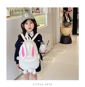 Detail of cute white canvas toddler backpack with pink rabbit ears and fluffy pom-pom