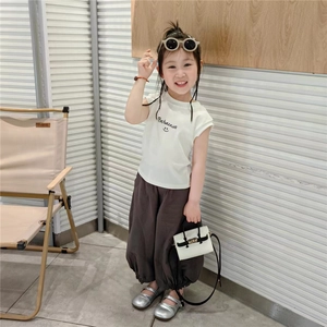 Vue détaillée du t-shirt blanc et du pantalon lanterne marron pour fille avec sac