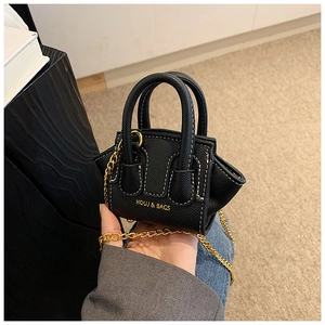 Détail du mini sac noir avec surpiqûres blanches et bandoulière chaîne dorée