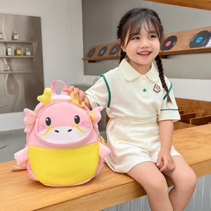 Pink and yellow cartoon dragon backpack for toddlers worn by a smiling young girl
