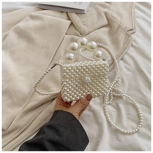 Detailed close-up of handmade faux pearl mini bag with large bead top handle and strap