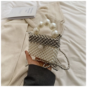 Detail of beaded mini bag showing cream pearls, silver beads and elegant pearl handle