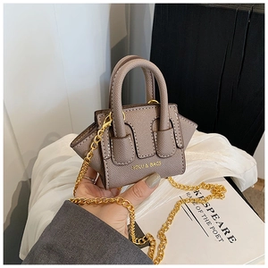 Détail d'un mini sac pour enfant en cuir taupe avec chaîne dorée et poignée ronde